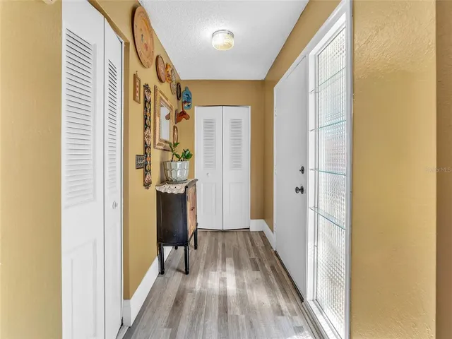 a view of a hallway with wooden floor and staircase