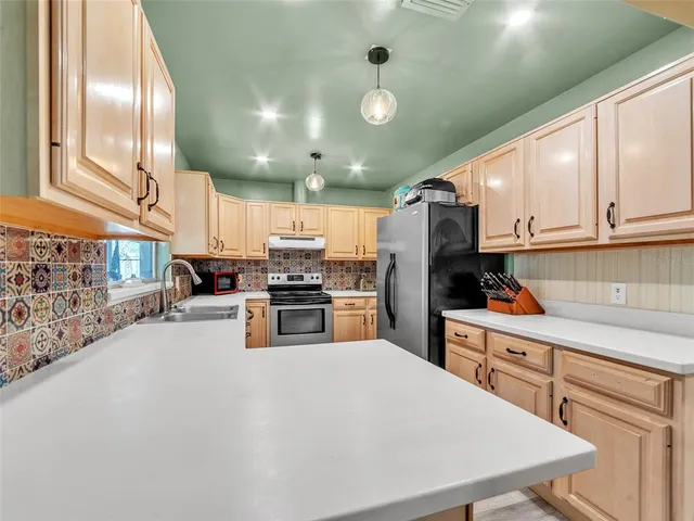 a kitchen with lots of counter top space cabinets and stainless steel appliances