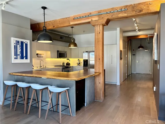 a kitchen with stainless steel appliances granite countertop a dining table and chairs