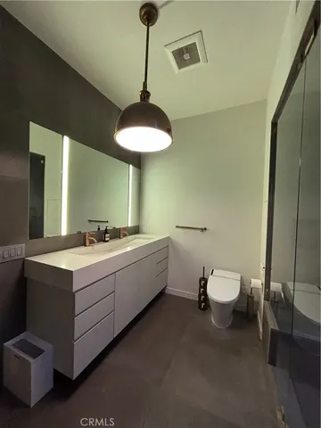 a bathroom with a double vanity sink toilet and a mirror
