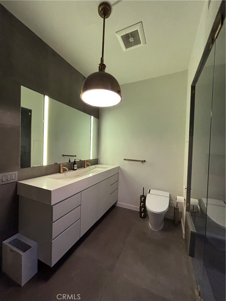 527 Molino Street, Unit 401 Los Angeles, CA 90013 - Photo 15 of 31 a bathroom with a double vanity sink toilet and a mirror