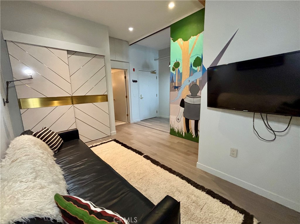 527 Molino Street, Unit 401 Los Angeles, CA 90013 - Photo 18 of 31 a hallway with a couch and a flat screen tv