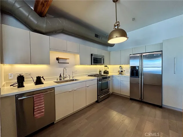 a kitchen with stainless steel appliances granite countertop a sink a stove and refrigerator