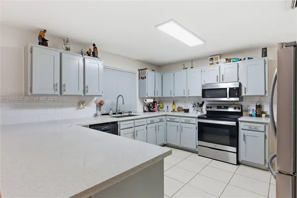 a kitchen with granite countertop white cabinets and stainless steel appliances