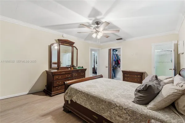 a bedroom with a bed and dresser with mirror