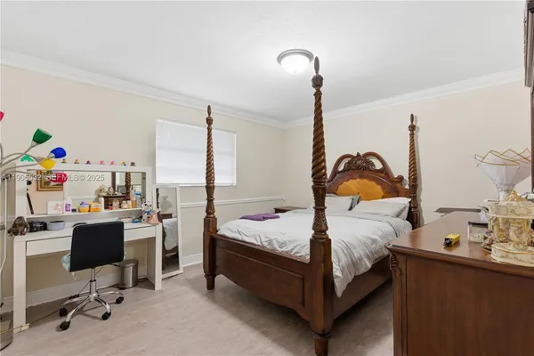 a bedroom with a bed and a computer on the desk
