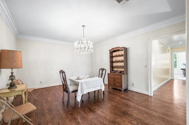 a view of a dining room with furniture a chandelier and wooden floor