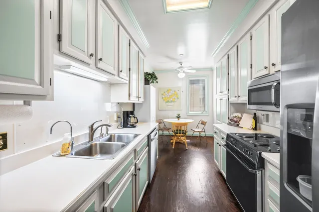 a kitchen with stainless steel appliances a refrigerator sink and white cabinets