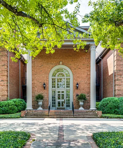 a front view of a house with a garden and plants