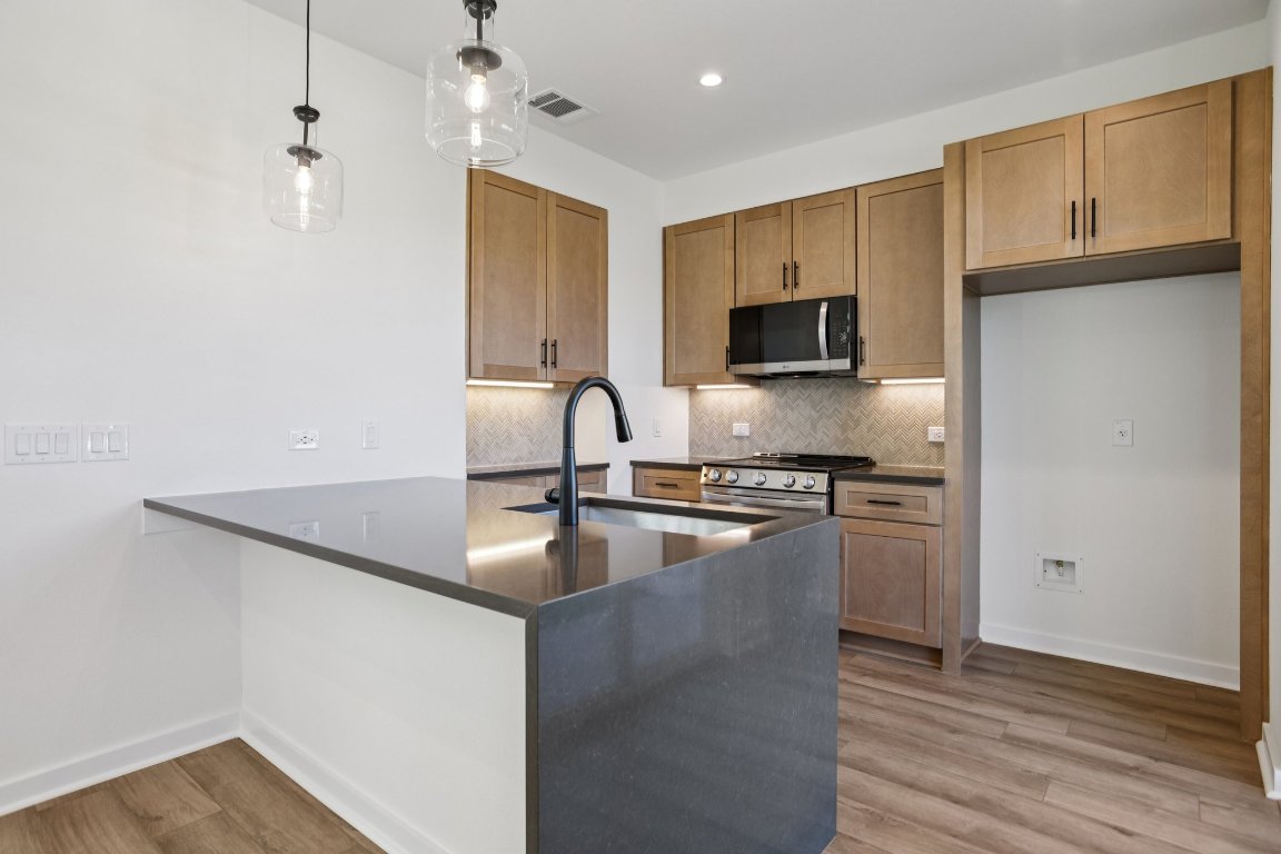 2414 Drew Lane, Unit 5 Austin, TX 78748 - Photo 11 of 33 a kitchen with granite countertop a sink and a stove top oven