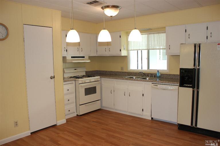290 Yosemite Road, Unit 290 San Rafael, CA 94903 - Photo 1 of 1 a kitchen with white cabinets and stainless steel appliances