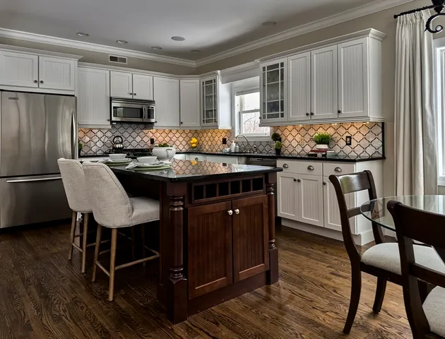a kitchen with granite countertop stainless steel appliances a stove a sink a refrigerator and cabinets