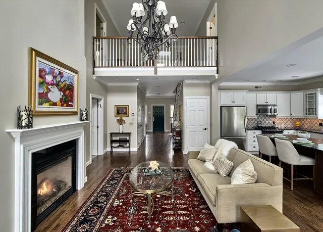 a living room with furniture a fireplace and a chandelier