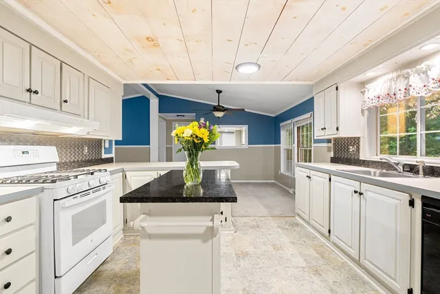 a kitchen with granite countertop a sink stove and cabinets