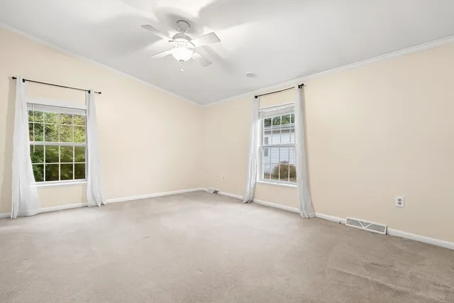 an empty room with a ceiling fan and a window