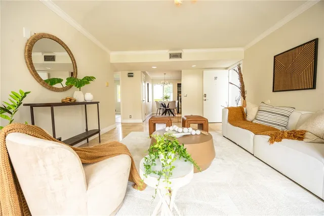 a living room with furniture a mirror and a potted plant