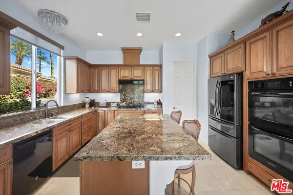 a kitchen with stainless steel appliances granite countertop a sink stove and cabinets