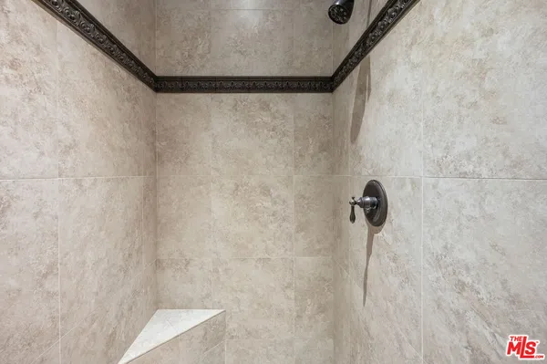a spacious en suite bathroom with a granite countertop double vanity