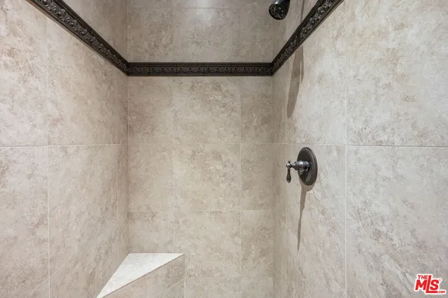 a spacious en suite bathroom with a granite countertop double vanity