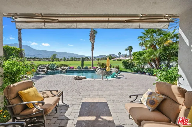 a swimming pool with outdoor seating and yard