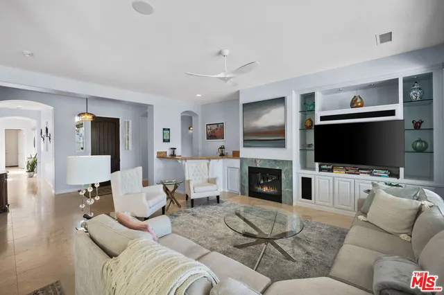 a living room with furniture flat screen tv and a large window