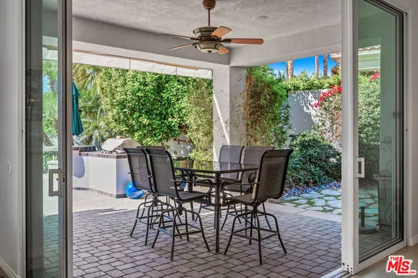 a open dining room with kitchen island furniture a rug a large window and chairs