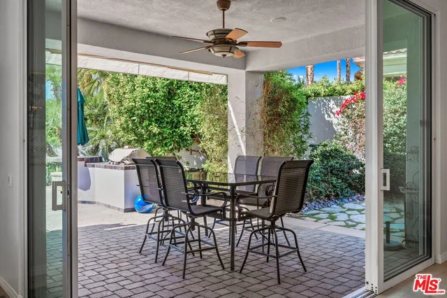 a open dining room with kitchen island furniture a rug a large window and chairs