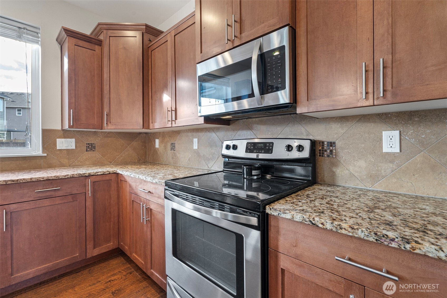 204 Balmer Street Southwest Orting, WA 98360 - Photo 8 of 29 a kitchen with stainless steel appliances granite countertop a sink stove and microwave