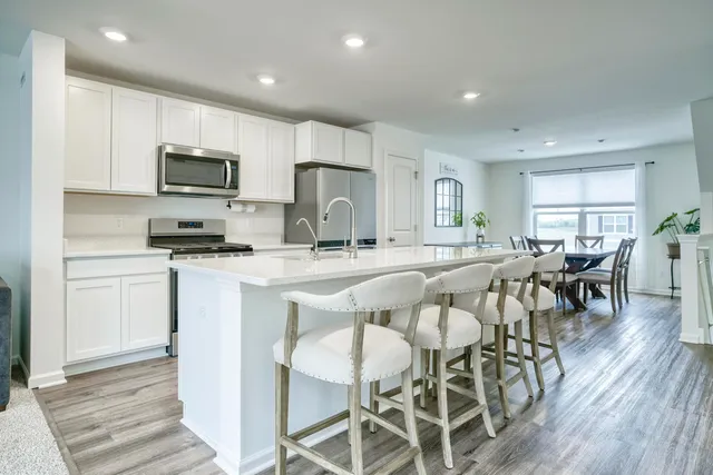 a kitchen with stainless steel appliances kitchen island granite countertop a refrigerator and microwave