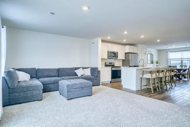 a living room with furniture and kitchen view