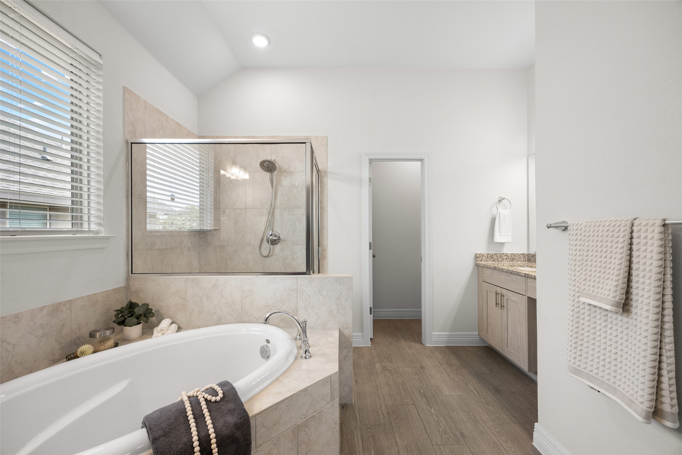 704 Muster Bend Georgetown, TX 78626 - Photo 20 of 38 Bathroom with vanity, a stall shower, a bath, dark wood-type flooring, and recessed lighting