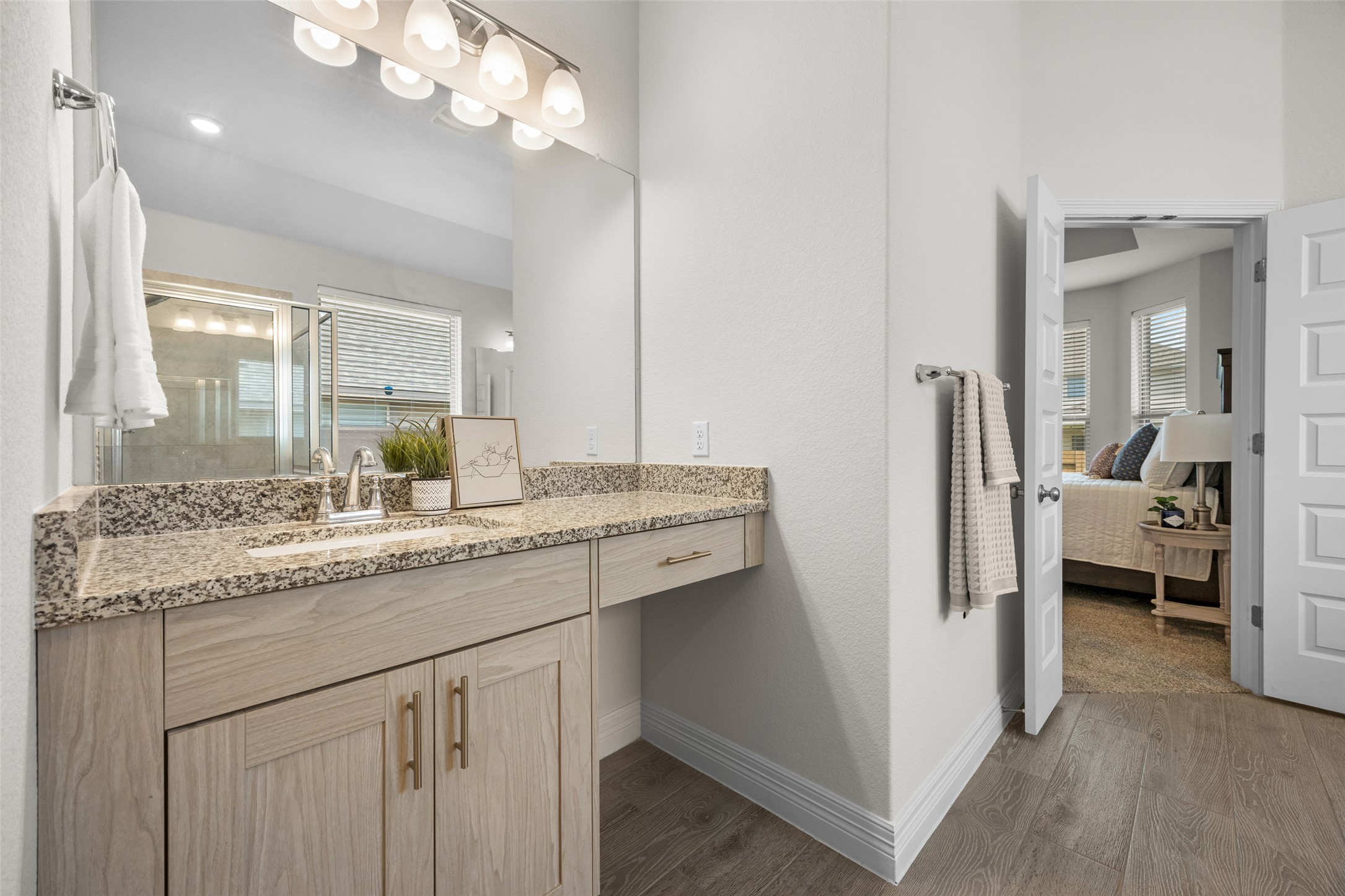 704 Muster Bend Georgetown, TX 78626 - Photo 22 of 38 Bathroom with vanity, dark wood-type flooring, a stall shower, and ensuite bath