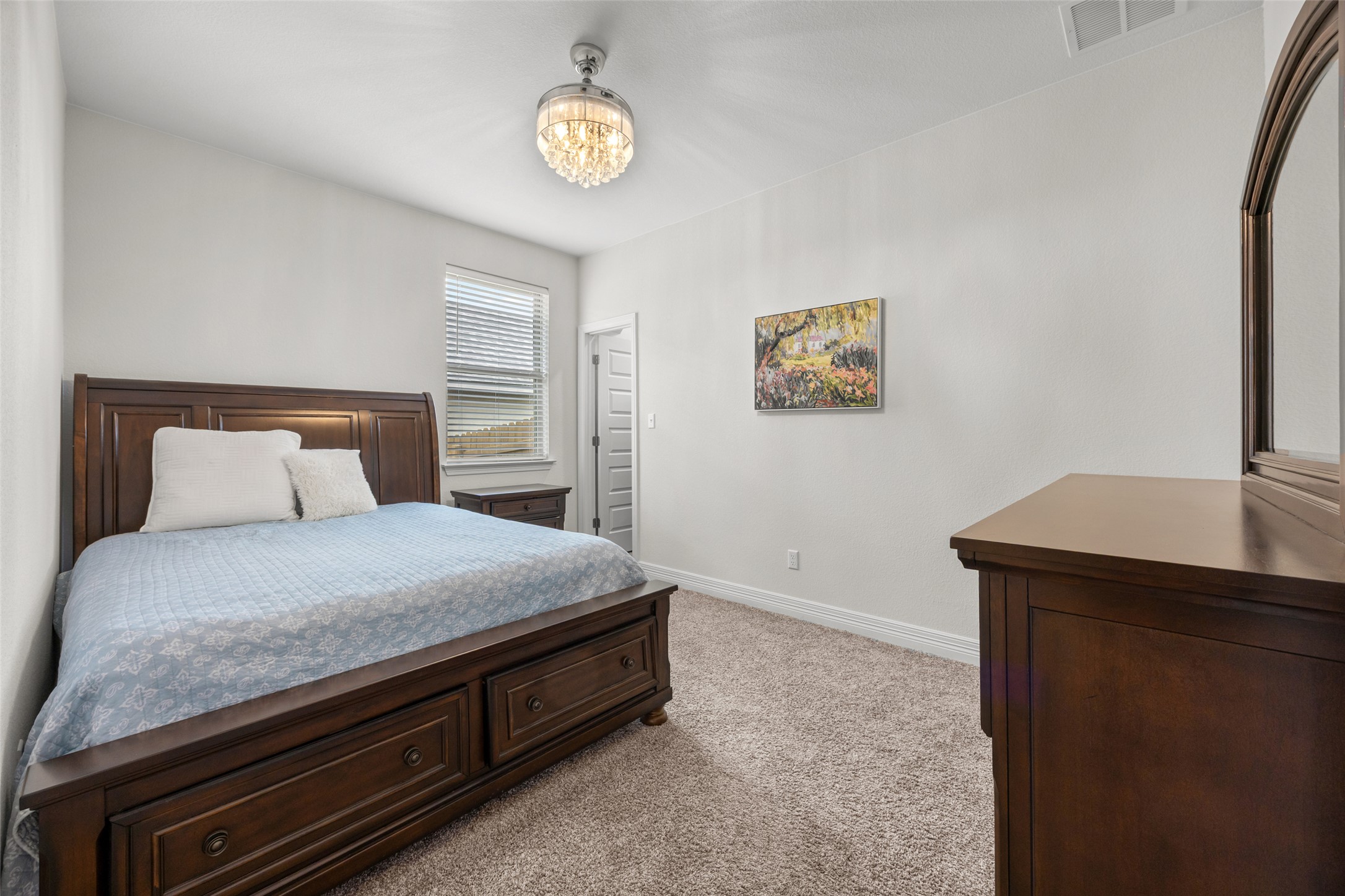 704 Muster Bend Georgetown, TX 78626 - Photo 23 of 38 Bedroom with light carpet and hanging lights
