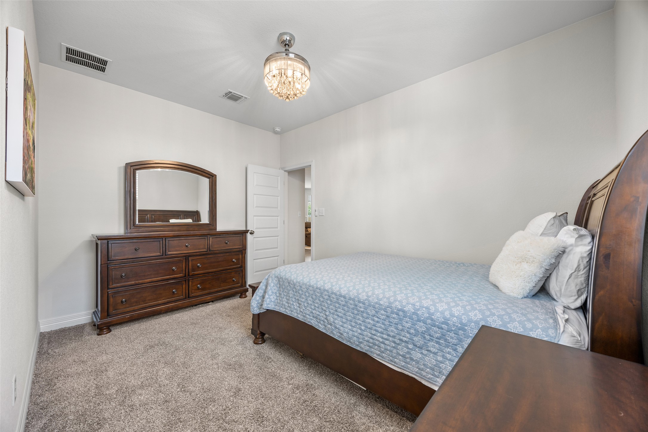 704 Muster Bend Georgetown, TX 78626 - Photo 25 of 39 Bedroom with light carpet and suspended lighting