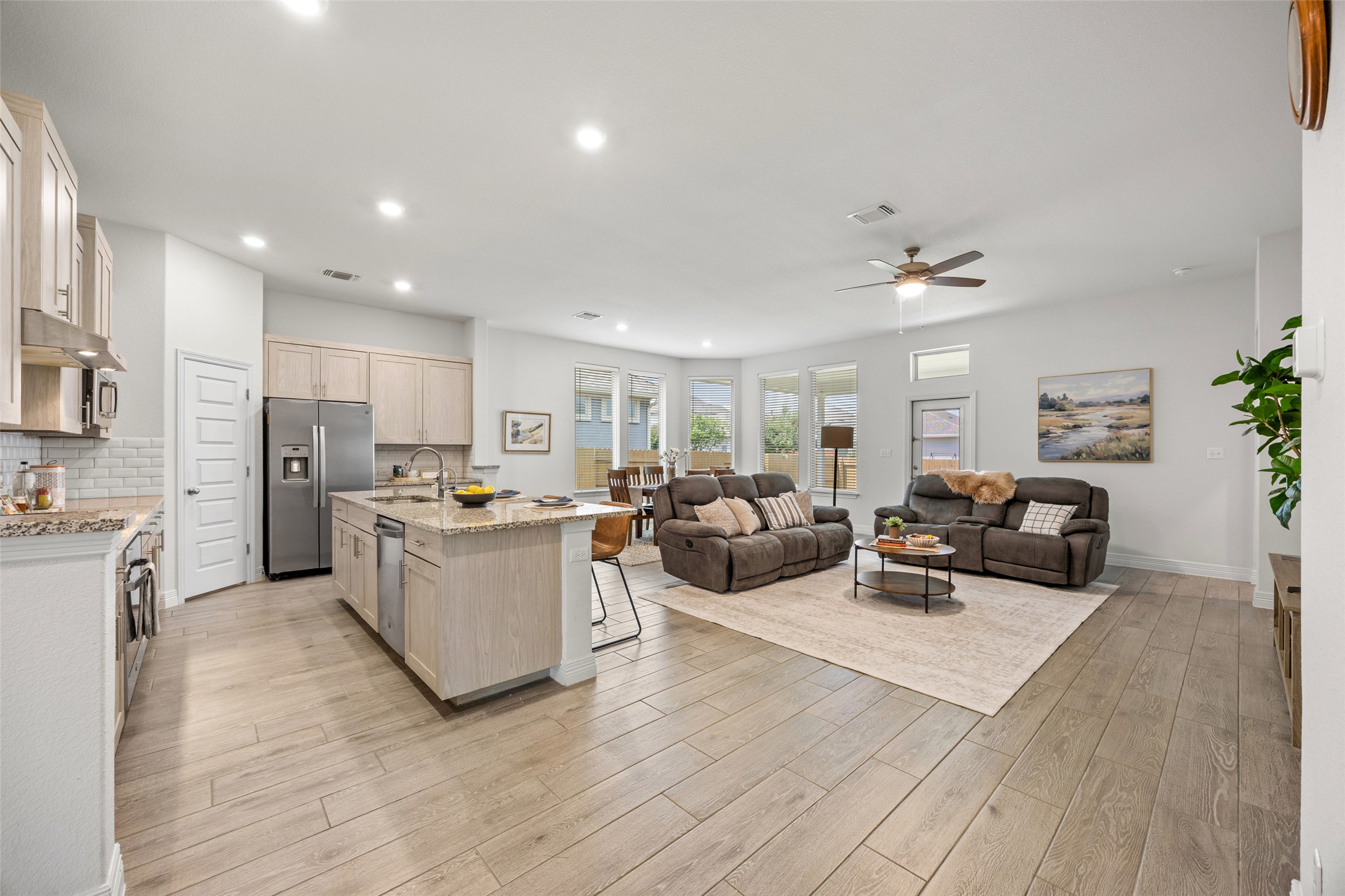 704 Muster Bend Georgetown, TX 78626 - Photo 38 of 38 Kitchen featuring open floor plan, light stone counters, an island with sink, ceiling fan, and stainless steel appliances