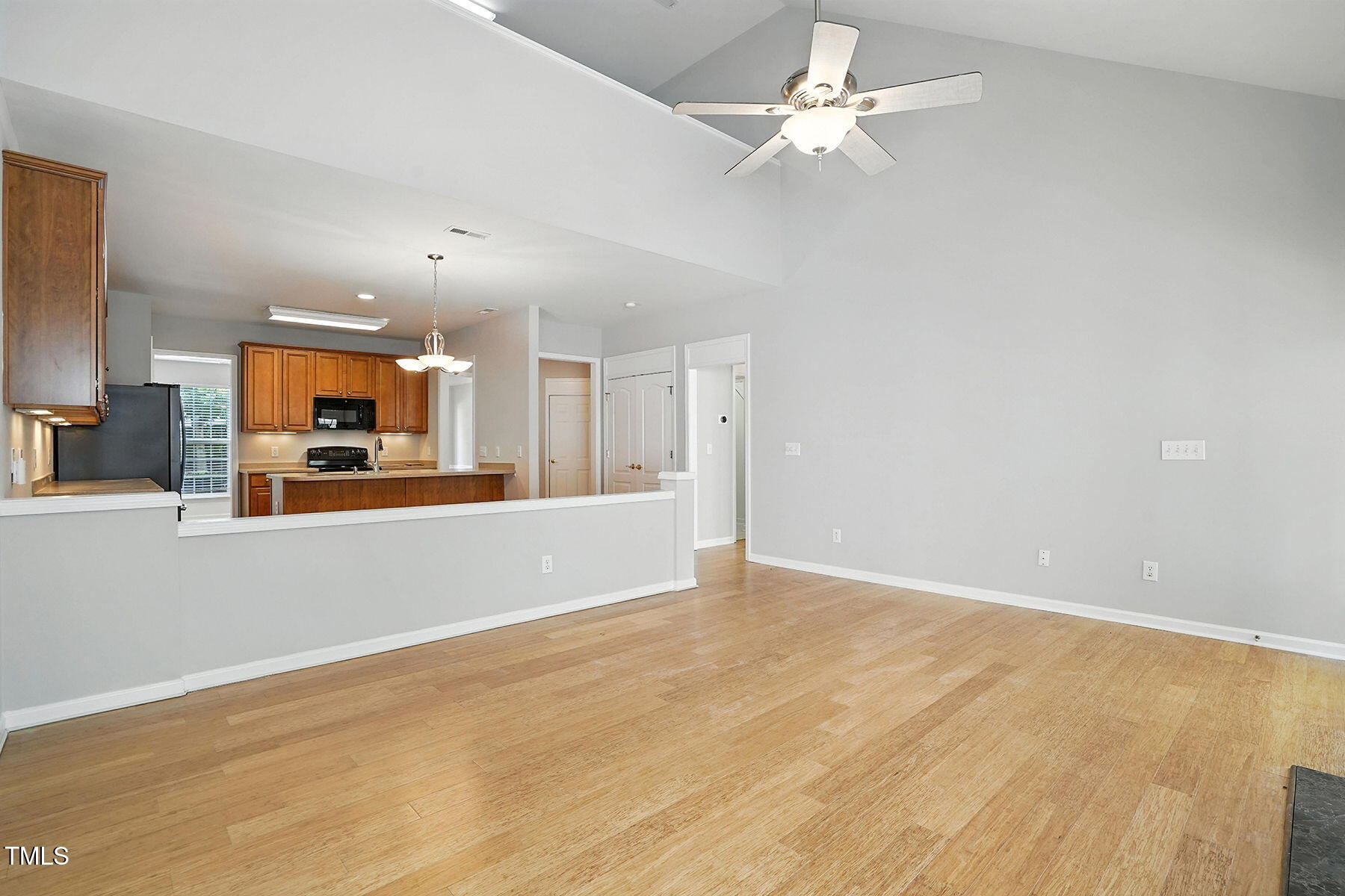 5421 Brandy Bay Road Raleigh, NC 27613 - Photo 13 of 25 an empty room with a kitchen and chandelier fan