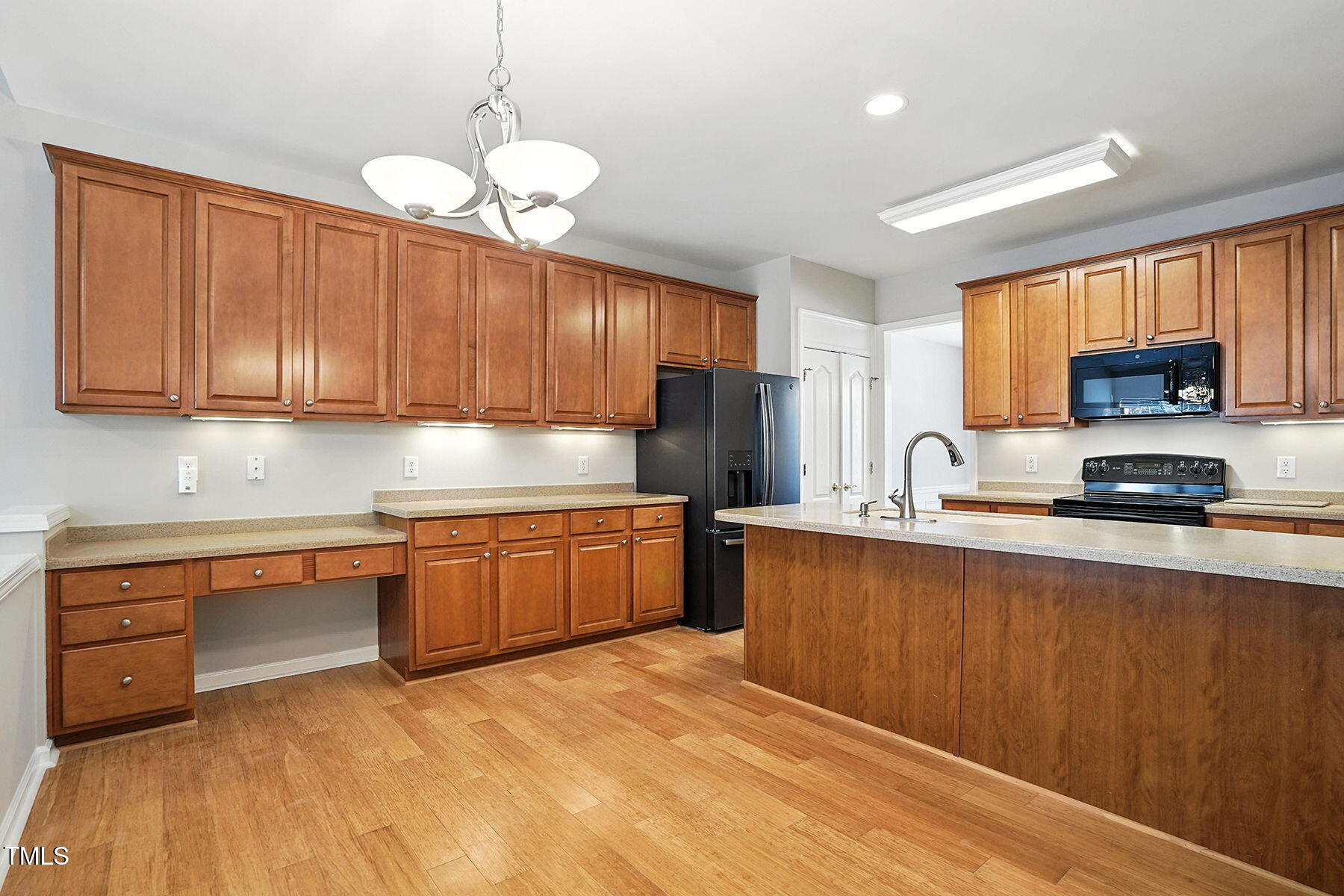 5421 Brandy Bay Road Raleigh, NC 27613 - Photo 7 of 25 a kitchen with stainless steel appliances granite countertop a sink a stove a refrigerator cabinets and wooden floor