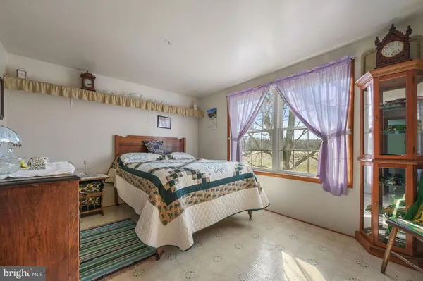 a living room with furniture kitchen view and a wooden floor