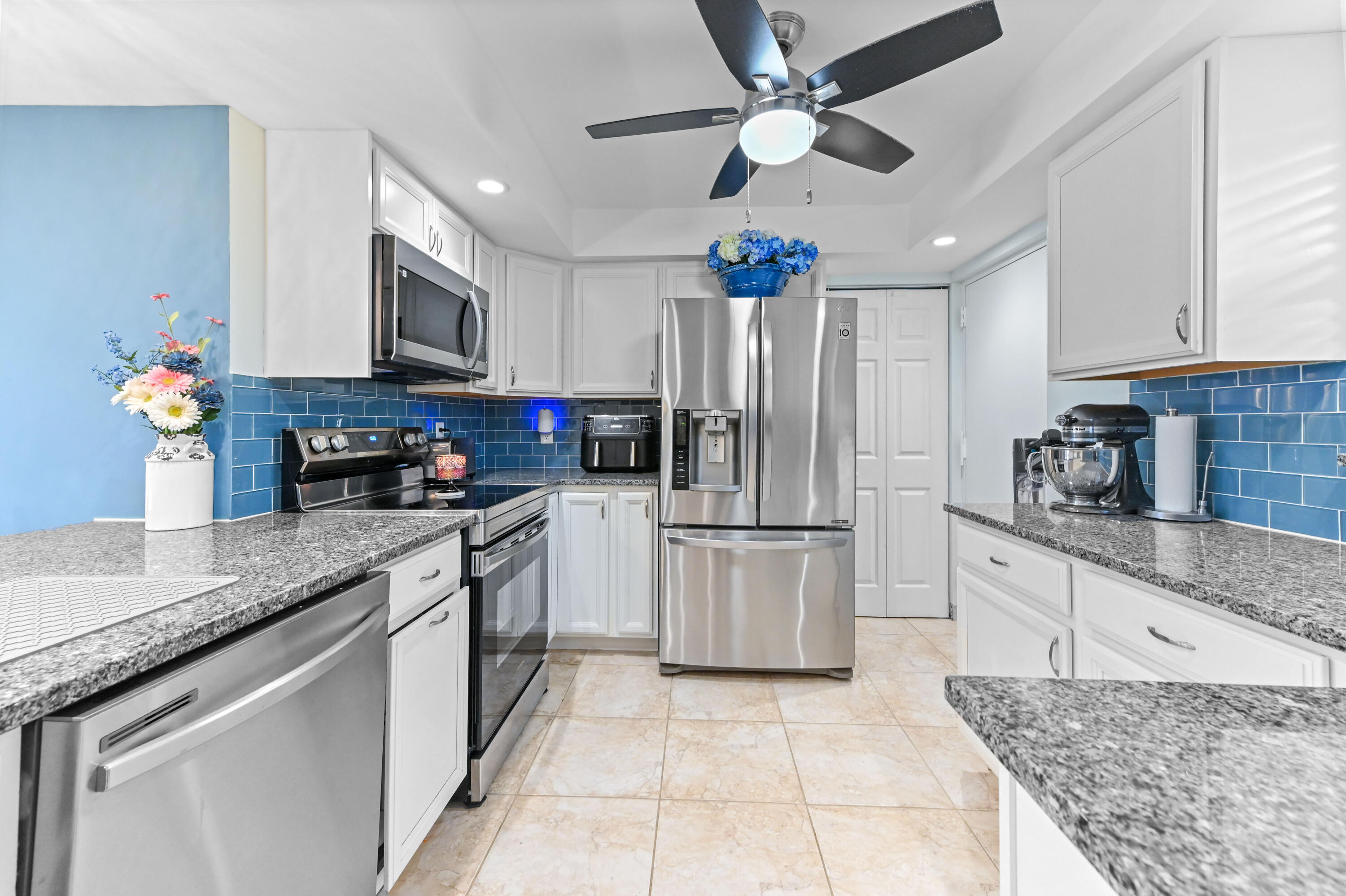 198 Northwest 67th Street, Unit 207 Boca Raton, FL 33487 - Photo 6 of 42 a kitchen with kitchen island granite countertop a sink a counter top space appliances and cabinets