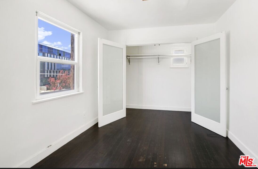 2140 20th Street, Unit A Santa Monica, CA 90405 - Photo 11 of 15 a view of an empty room with wooden floor and a window