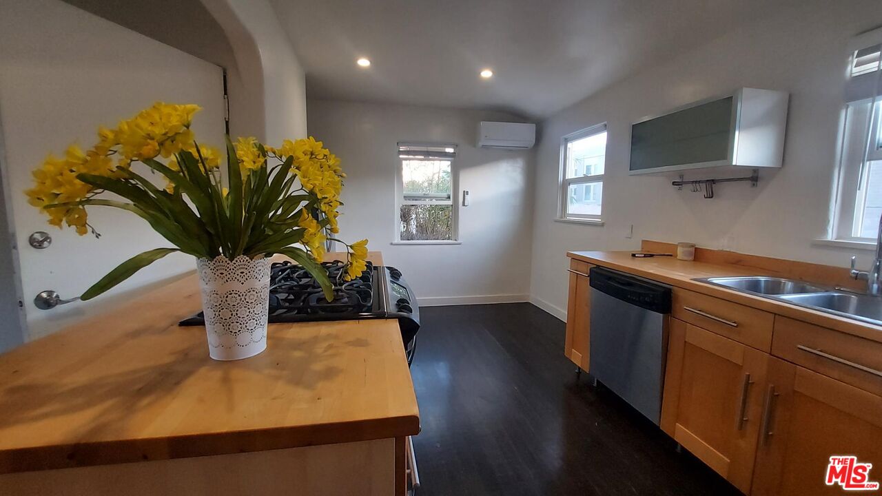 2140 20th Street, Unit A Santa Monica, CA 90405 - Photo 9 of 15 a kitchen with stainless steel appliances granite countertop a sink a stove and a wooden floors
