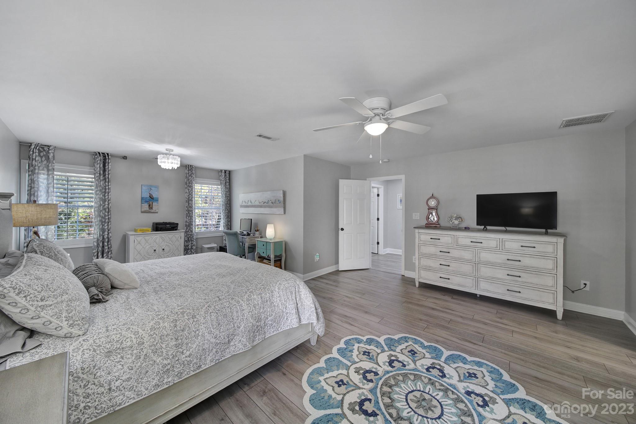 4028 Windward Drive Tega Cay, SC 29708 - Photo 24 of 48 a bedroom with a large bed a flat tv screen and dresser