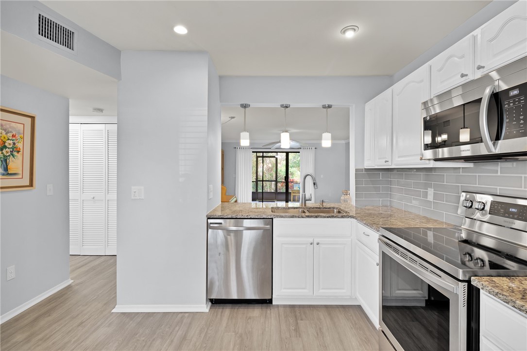 9645 Estuary Way, Unit 1 Sebastian, FL 32958 - Photo 11 of 36 a kitchen with stainless steel appliances a sink cabinets and wooden floor