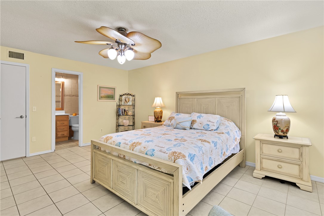 9645 Estuary Way, Unit 1 Sebastian, FL 32958 - Photo 16 of 36 a bedroom with a bed and a chandelier