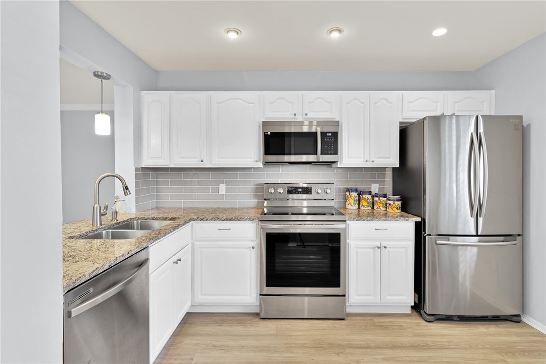 9645 Estuary Way, Unit 1 Sebastian, FL 32958 - Photo 10 of 36 a kitchen with stainless steel appliances a stove microwave and refrigerator