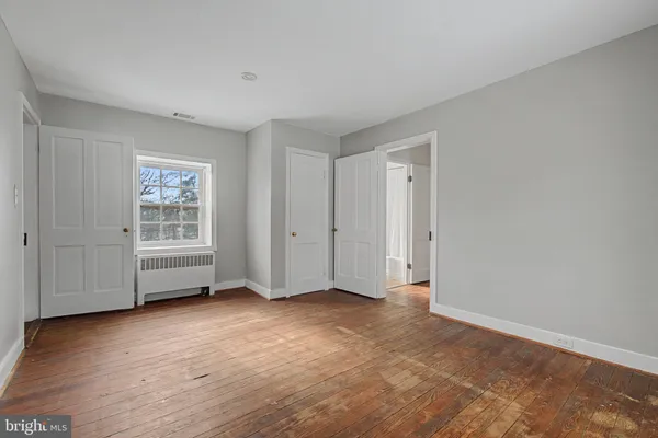 a view of empty room with wooden floor and window