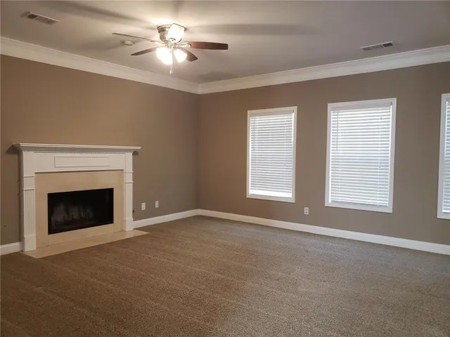 a view of empty room with fan and fireplace