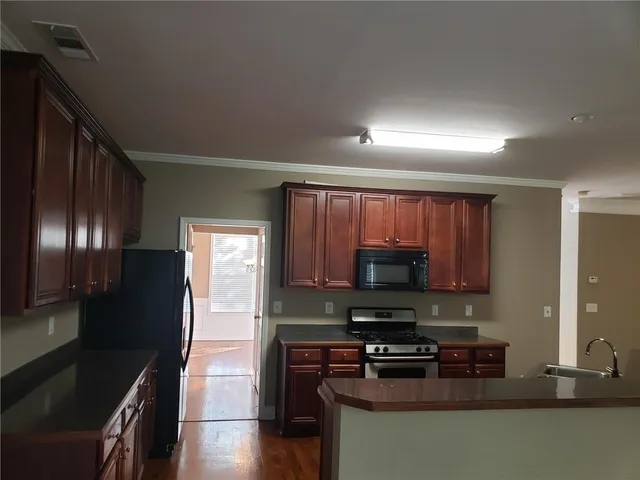 a kitchen with stainless steel appliances granite countertop a stove a refrigerator a sink and dishwasher