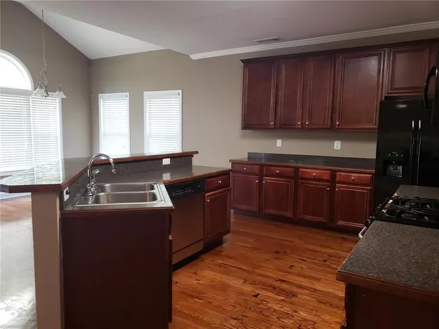 a kitchen with a stove sink and cabinets