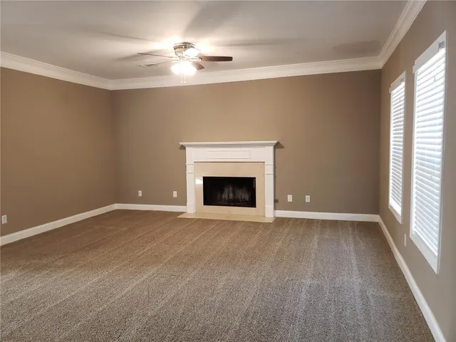 a view of an empty room with a fireplace and a window